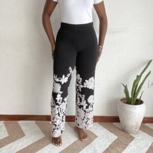 Black background white floral hem border straight-leg pants, front view